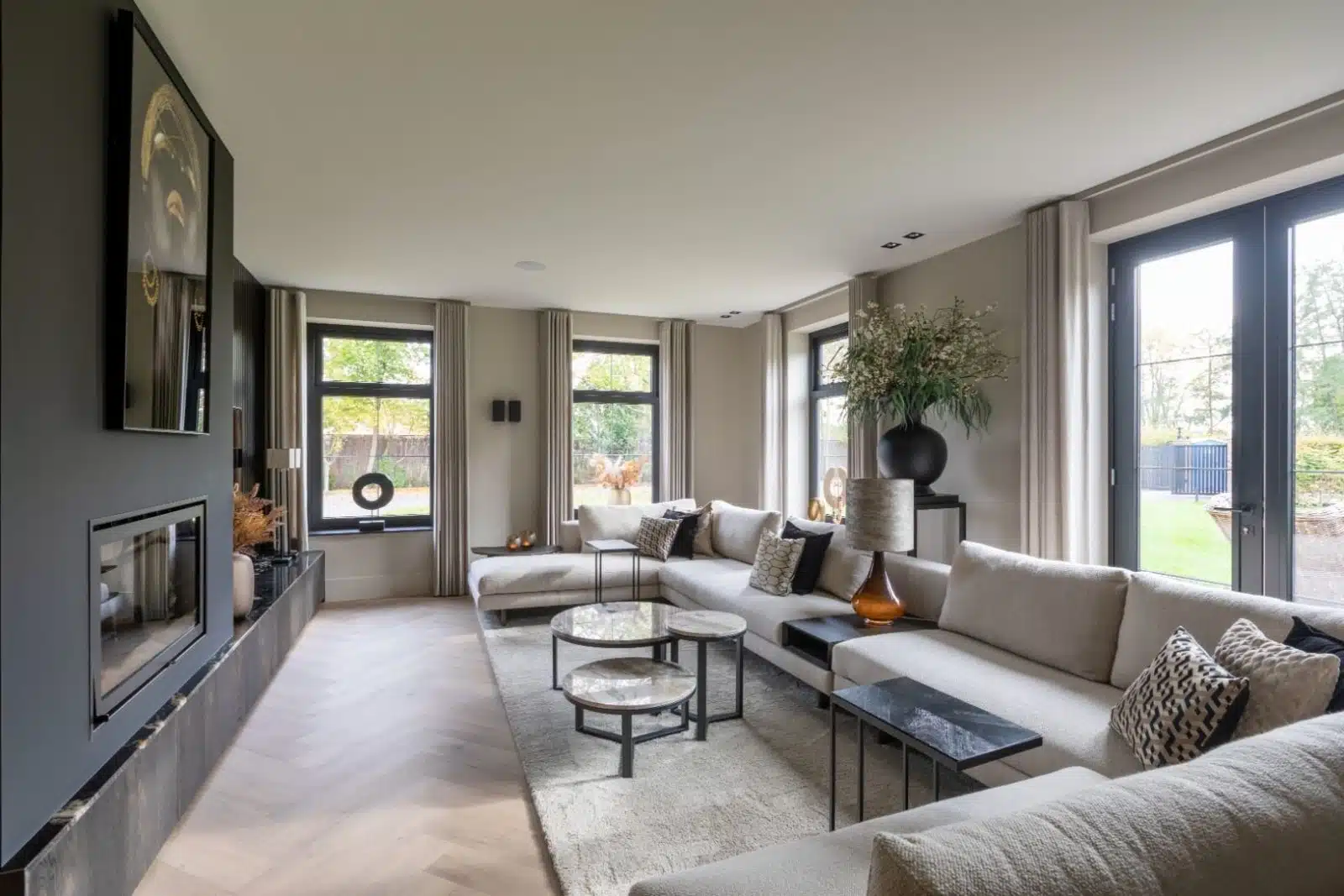 Lichte woonkamer met grote kozijnen en een schuifpui naar de tuin